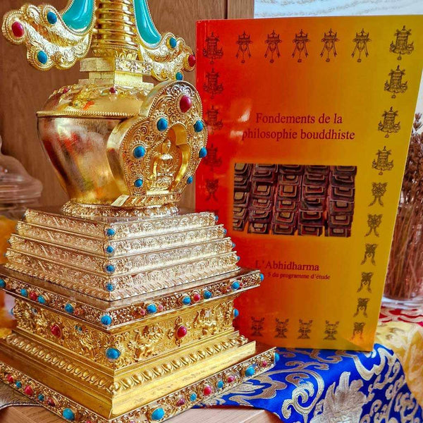 Stupa bouddhiste doré orné de pierres précieuses et livre sur la philosophie bouddhiste tibétaine