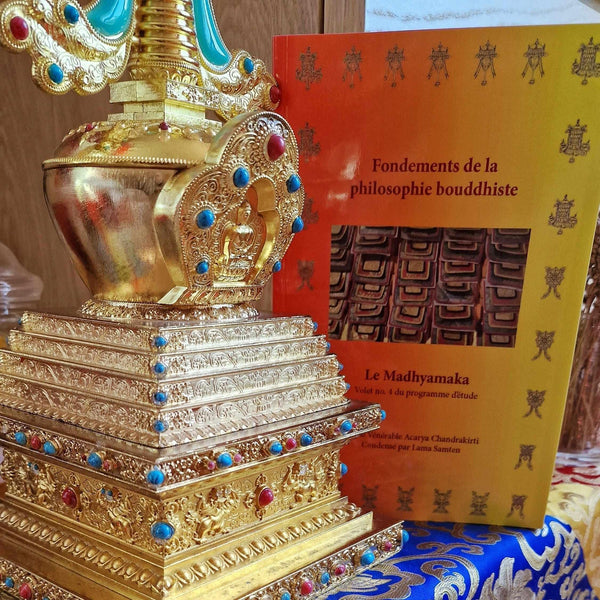 Stupa bouddhiste doré orné de pierres précieuses et livre sur la philosophie bouddhiste tibétaine