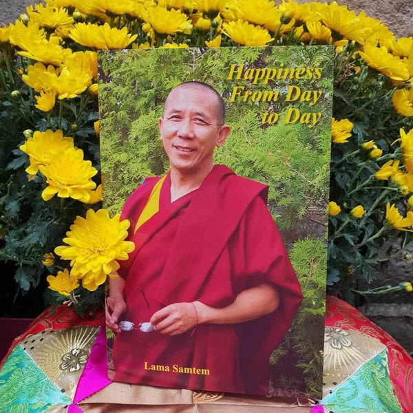 Livre 'Happiness From Day to Day' par Lama Samten, entouré de fleurs jaunes, philosophie bouddhiste tibétaine