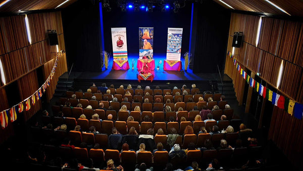 Conférence sur la méditation bouddhiste avec Lama Samten, drapeaux tibétains, salle remplie