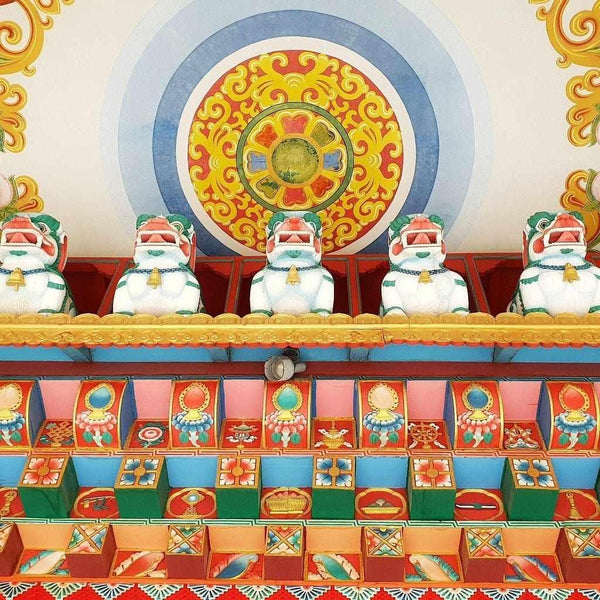 Statues de lions bouddhistes et roues de prière colorées, symboles de la culture tibétaine