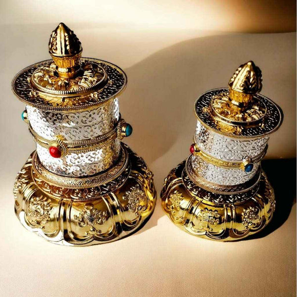Objets bouddhistes tibétains ornés, roues de prière en métal doré et argenté avec pierres colorées