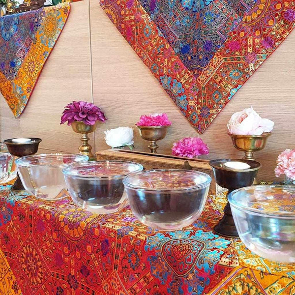 Offrandes bouddhistes avec bols d'eau, fleurs et tissus colorés de l'Himalaya pour méditation