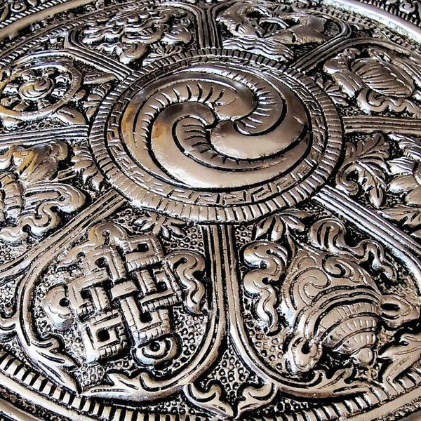 Plaque métallique bouddhiste tibétaine ornée de symboles sacrés et motifs traditionnels de l'Himalaya