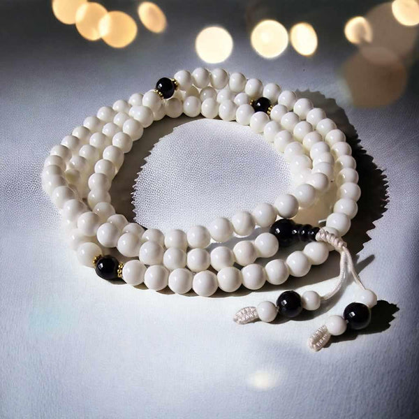 Chapelet bouddhiste blanc avec perles noires, objet de méditation tibétaine et philosophie bouddhiste