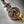 Pendentif bouddhiste tibétain avec nœud éternel doré, pierre bleue et perles colorées, symbole de sagesse et protection