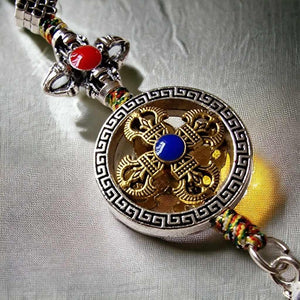 Pendentif bouddhiste tibétain avec nœud éternel doré, pierre bleue et perles colorées, symbole de sagesse et protection