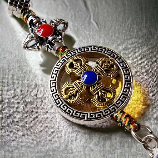 Pendentif bouddhiste tibétain avec nœud éternel doré, pierre bleue et perles colorées, symbole de sagesse et protection