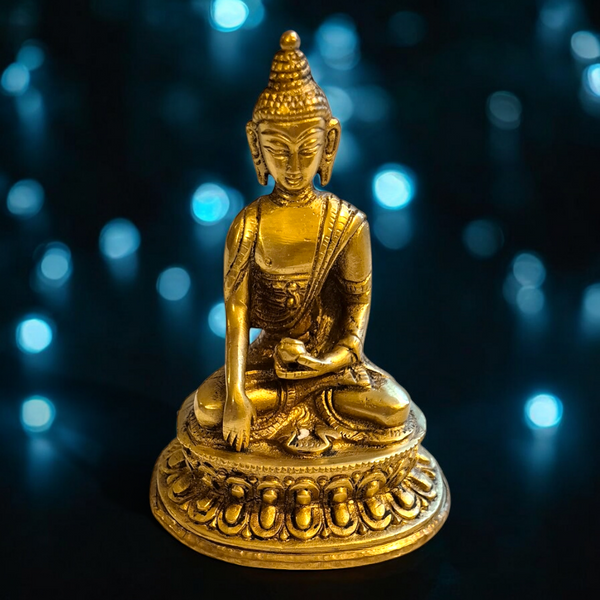 Statue dorée de Bouddha en méditation, style tibétain, sur socle orné, lumière bleue en arrière-plan
