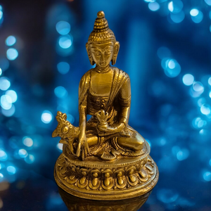 Statue dorée de Bouddha assis en méditation, symbole de la philosophie bouddhiste tibétaine