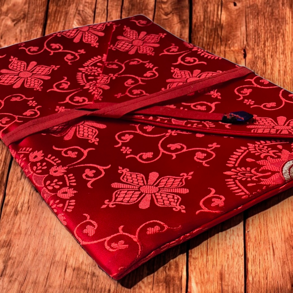 Coussin de méditation tibétain rouge à motifs floraux, tissu brodé, posé sur bois
