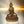 Statue dorée de Bouddha en méditation, style tibétain, sur socle orné, lumière douce
