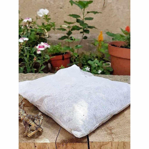 Sachet de méditation bouddhiste tibétaine en tissu naturel, avec objet rituel doré, jardin en arrière-plan