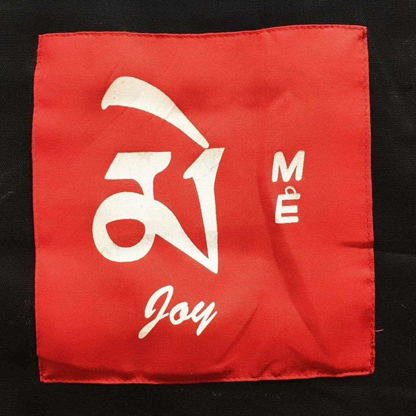 Écharpe rouge bouddhiste avec symbole tibétain 'Joy' et lettres 'MÉ', objet de méditation et culture himalayenne
