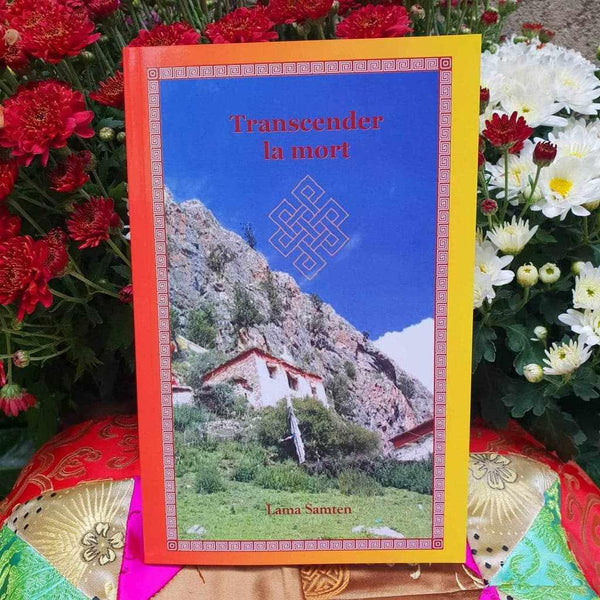 Livre 'Transcender la mort' par Lama Samten, philosophie bouddhiste tibétaine, entouré de fleurs et tissus colorés
