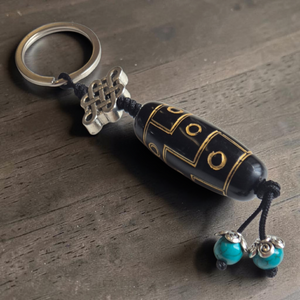 Porte-clés bouddhiste avec nœud infini, perle noire dorée et turquoises, symbole de sagesse tibétaine
