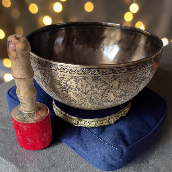 Bol tibétain gravé avec marteau en bois, sur coussin bleu, pour méditation et bien-être spirituel