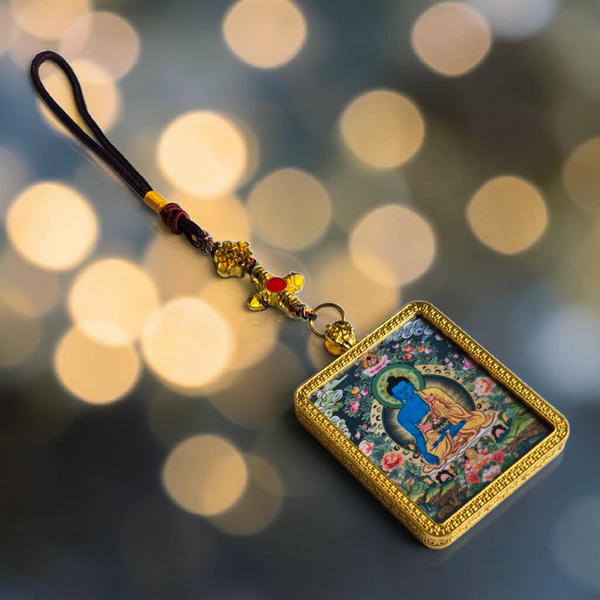 Pendentif bouddhiste tibétain avec image de Bouddha bleu, cadre doré et cordon tressé, symbole de méditation et sagesse