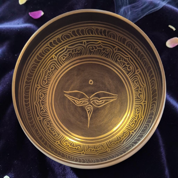 Bol tibétain gravé avec symbole bouddhiste, sur velours violet, pétales et fumée d'encens