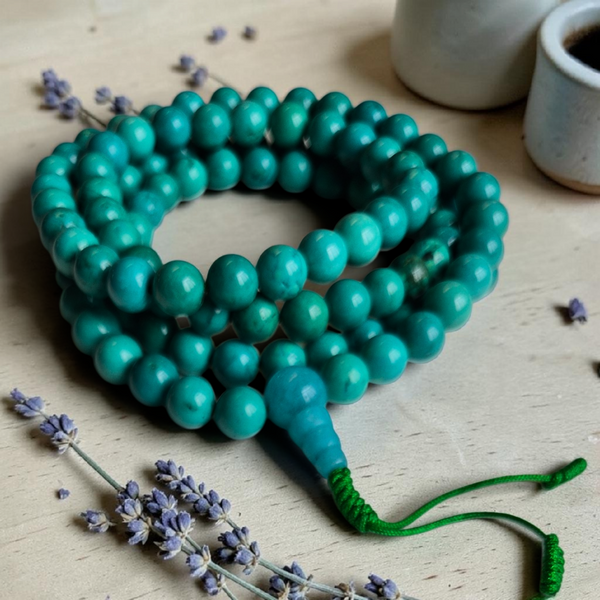 Chapelet bouddhiste en turquoise avec perles lisses et nœud vert, idéal pour la méditation et la pratique spirituelle.