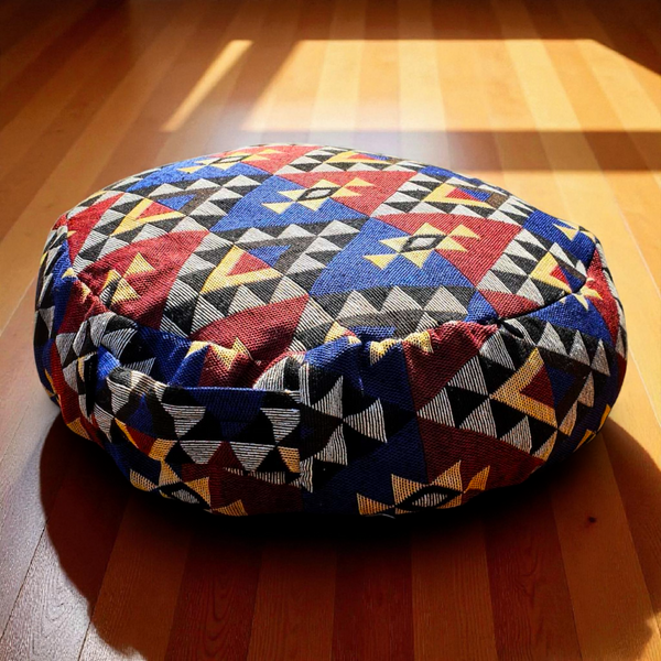 Coussin de méditation tibétain motif géométrique coloré sur parquet