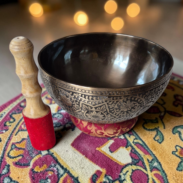 Bol tibétain gravé avec maillet en bois, sur tapis coloré, pour méditation et bien-être spirituel