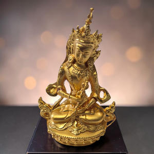 Statue dorée de Bouddha assis en méditation, symbole de la philosophie bouddhiste tibétaine