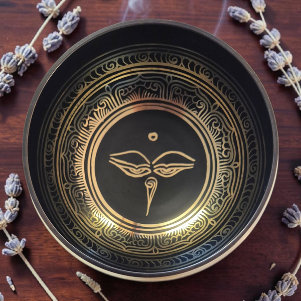 Bol tibétain noir et doré avec symbole bouddhiste, entouré de lavande séchée pour méditation