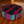 Coussin de méditation tibétain à motifs colorés pour pratique bouddhiste, posé sur sol en bois