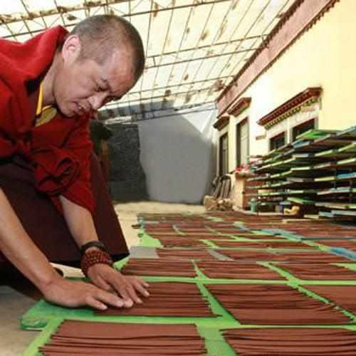 Moine bouddhiste tibétain préparant des bâtonnets d'encens traditionnels dans un atelier